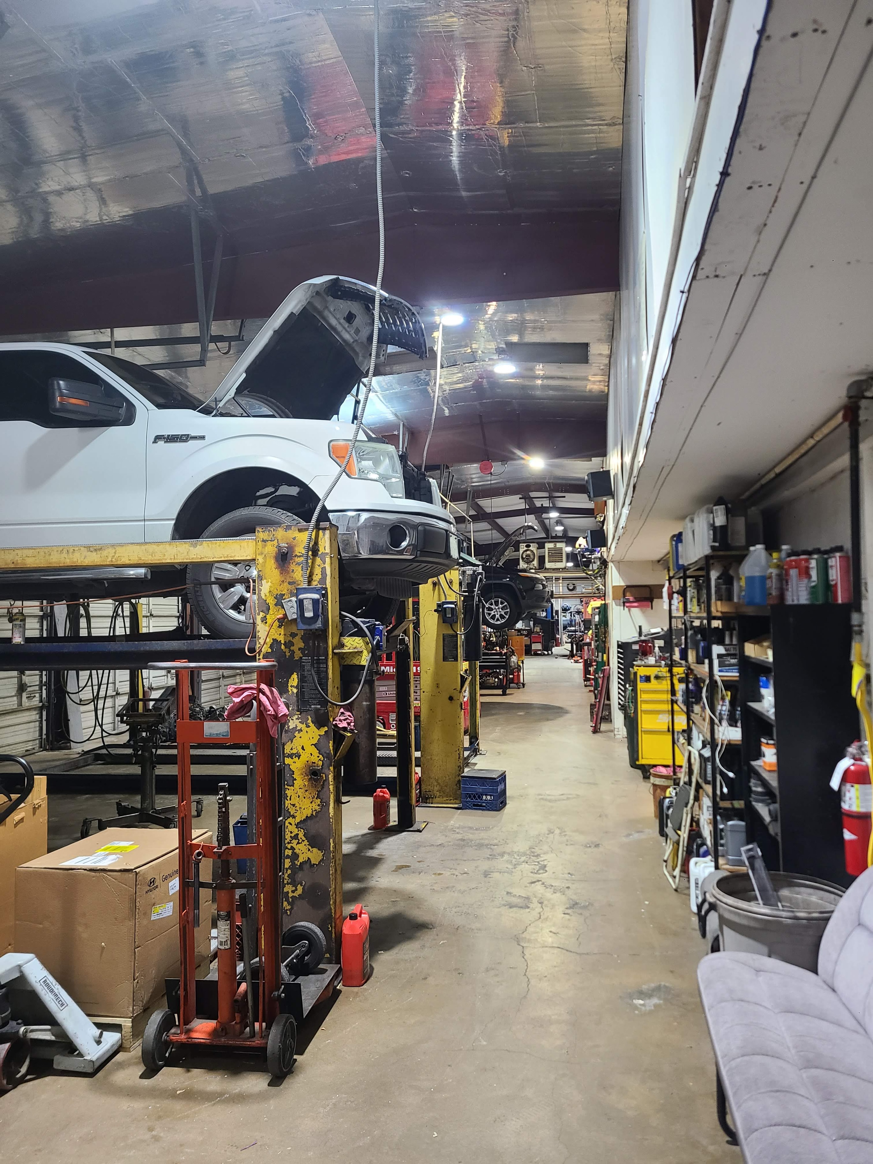 Riley Auto Care & Transmissions service bays with vehicles undergoing auto repair in San Marcos TX