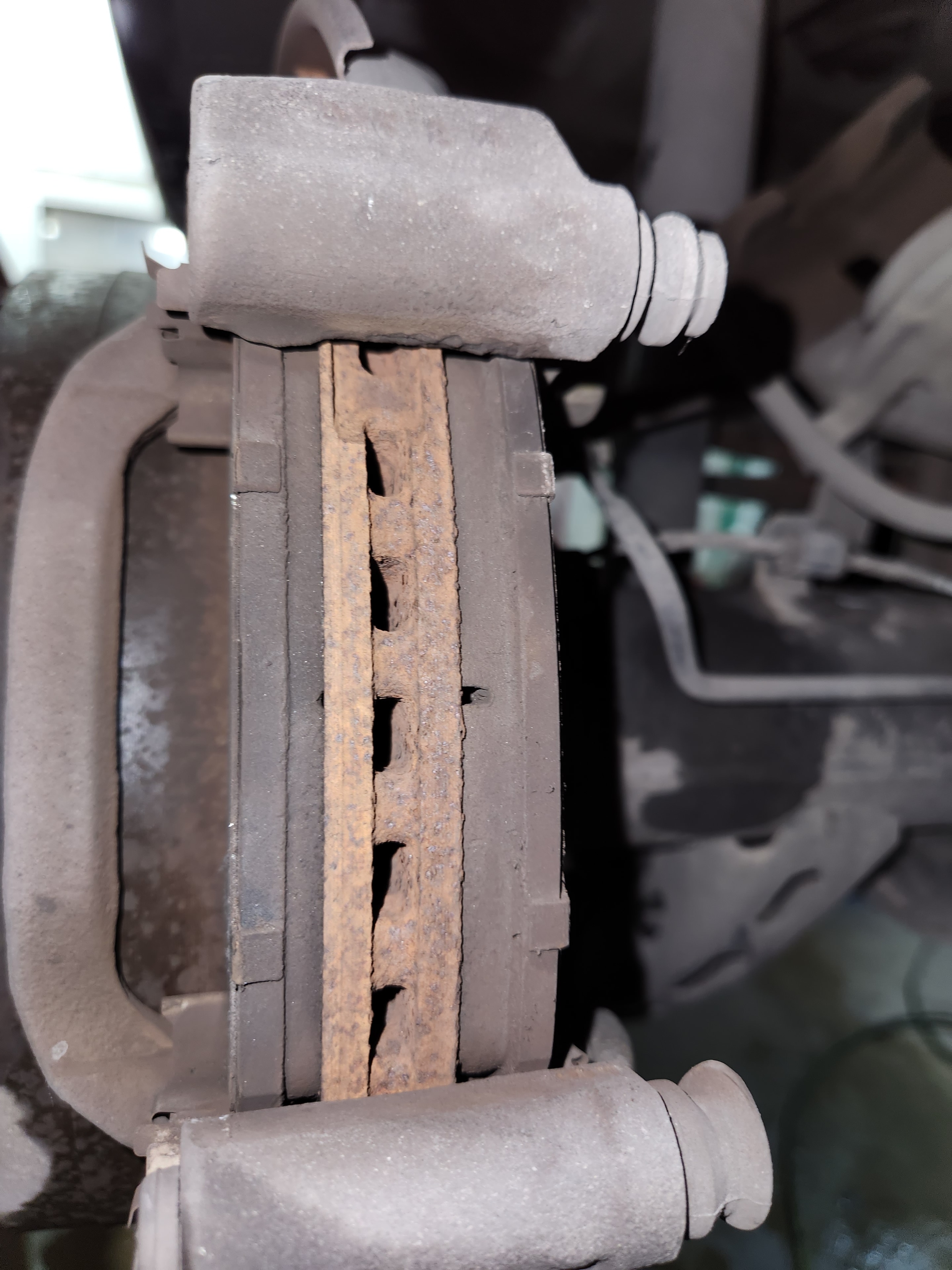 Severely worn brake pads with cracked friction material inspected at Riley Auto Care San Marcos TX