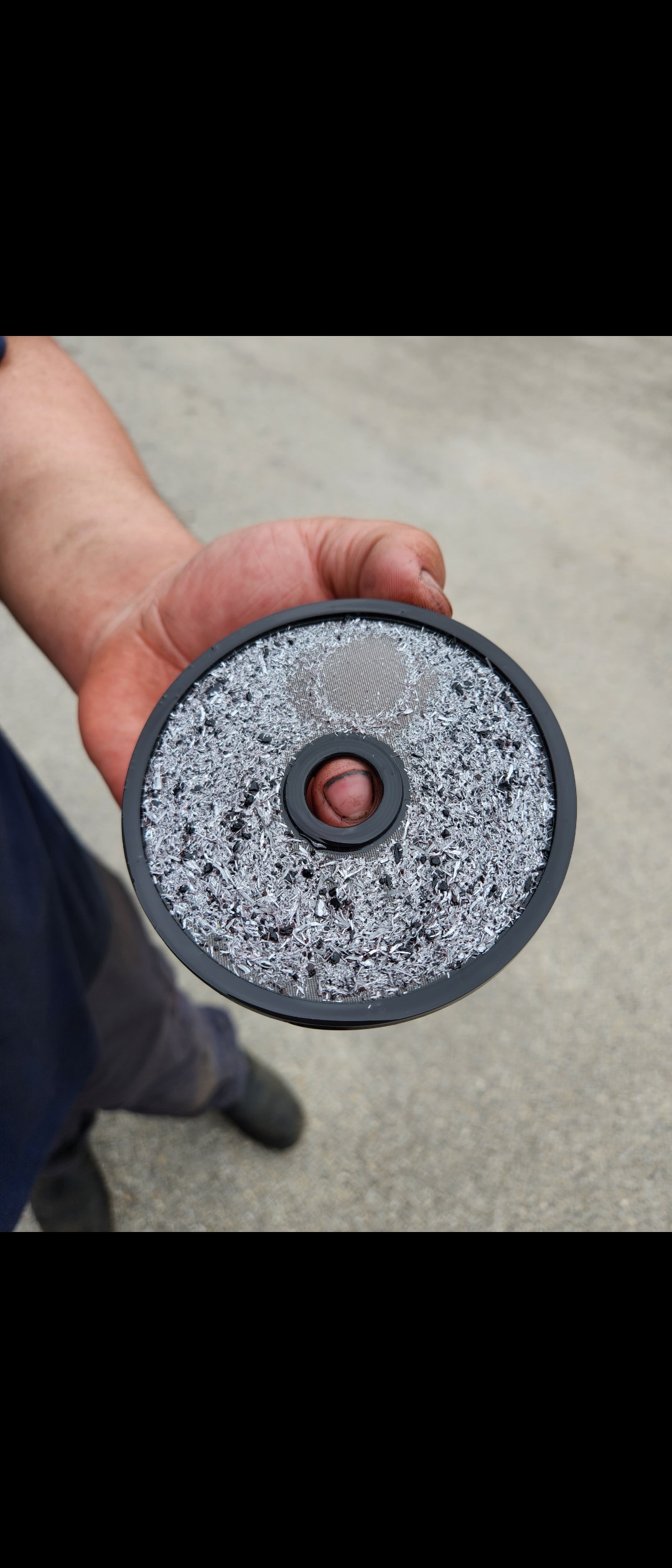 Hot oil flush machine filter screen loaded with large metallic shavings and transmission debris captured during cooler service at Riley Auto Care San Marcos TX